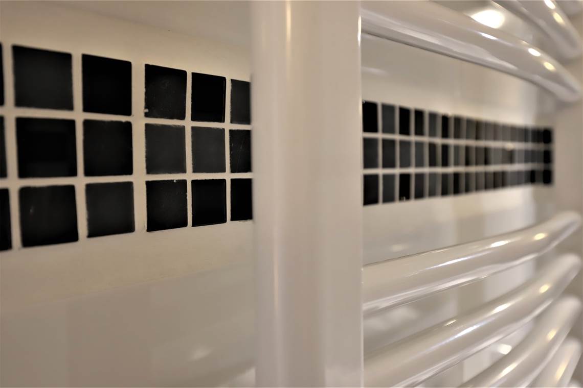 Salle de bain avec douche sur baignoire