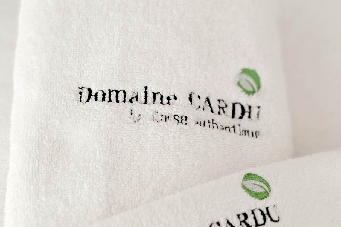 Linge de toilette de qualité brodé au nom du Domaine Cardu pour un accueil premium.