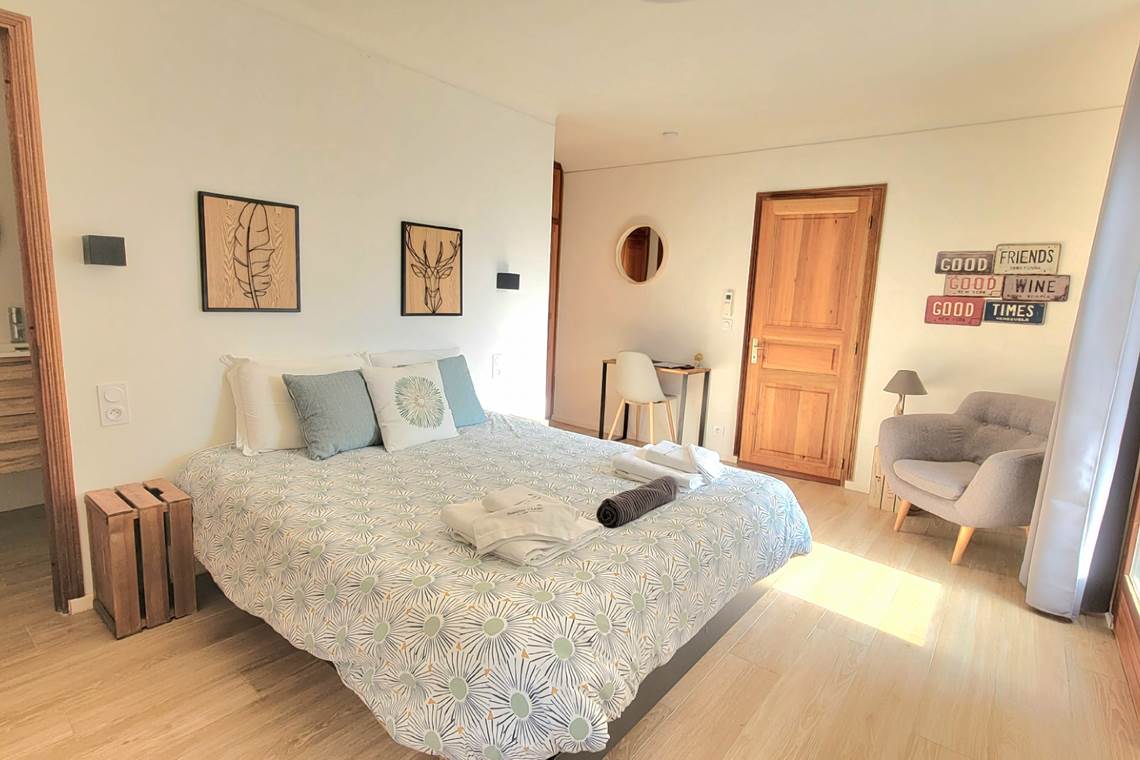 Chambre d'amis 1 spacieuse avec lit double, décoration naturelle et ambiance lumineuse au Domaine Cardu.