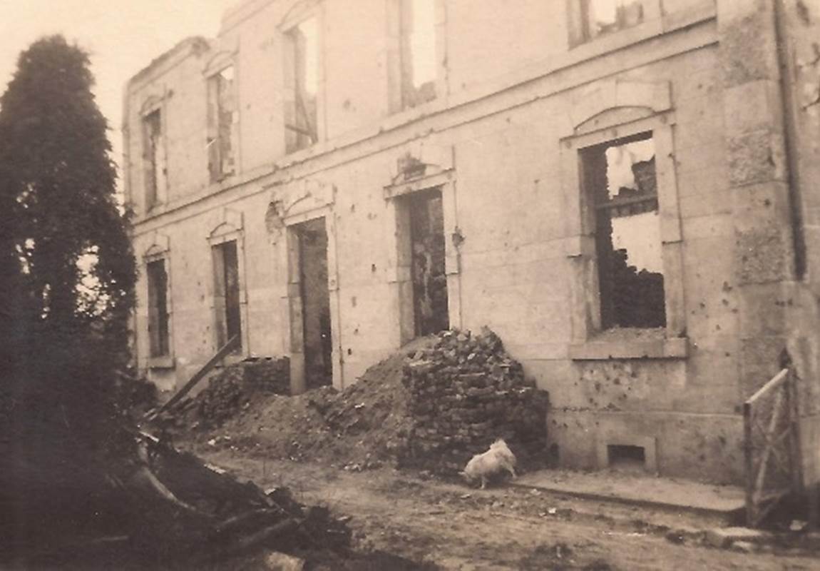 De resten van goede bakstenen liggen opgestapeld aan weerszijden van de voordeur.-page