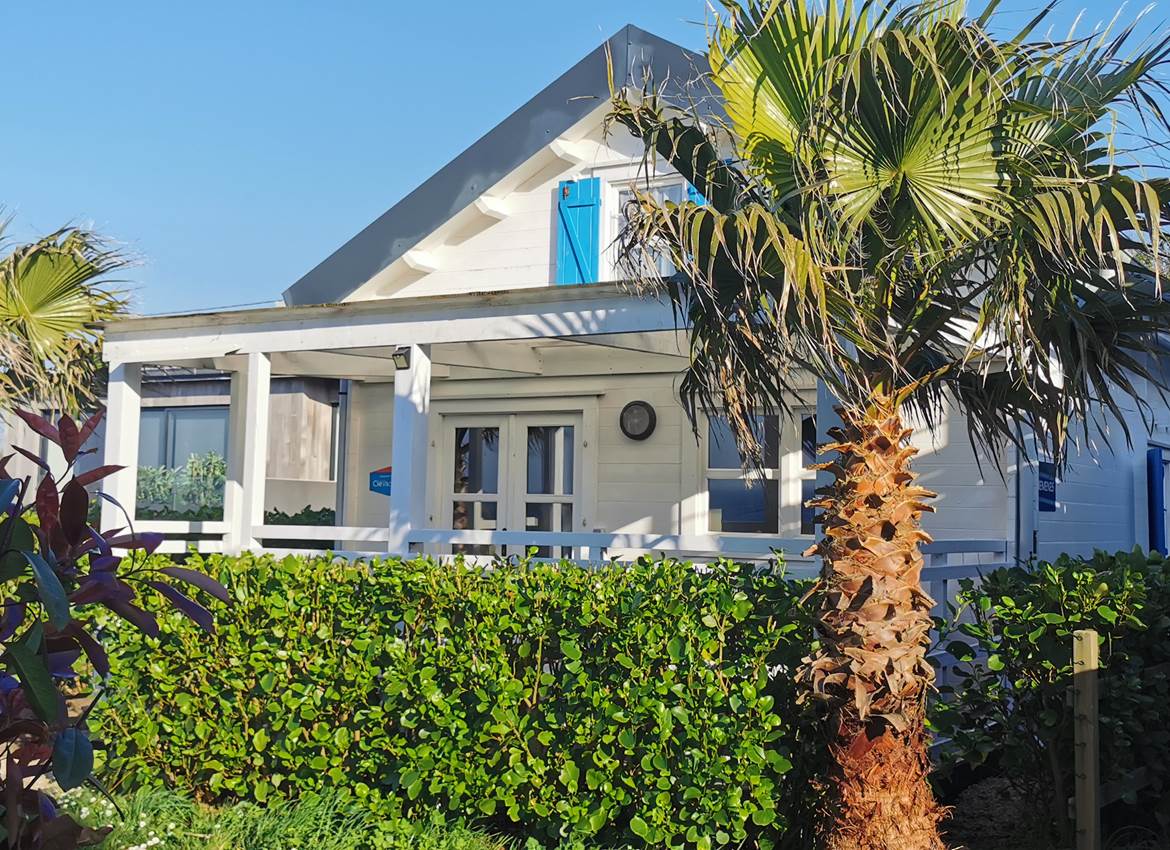 Chalet cosy en bois avec terrasse couverte dans son écrin de verdure pour des vacances en famille aux Chalets de Kerescar en Bretagne