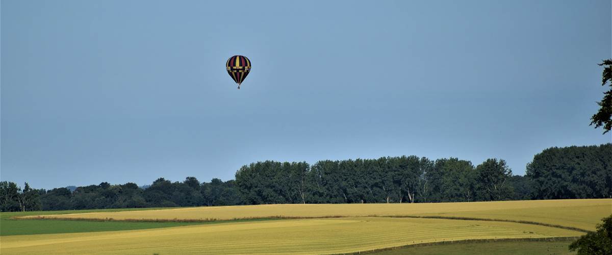 Montgolfière survolant la plaine au fond du jardin