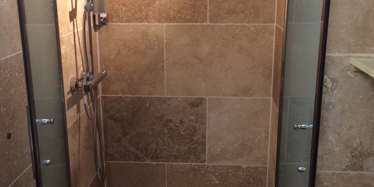 Intérieur de la douche italienne de 100x80 cm avec les porte du pare-douche ouvertes