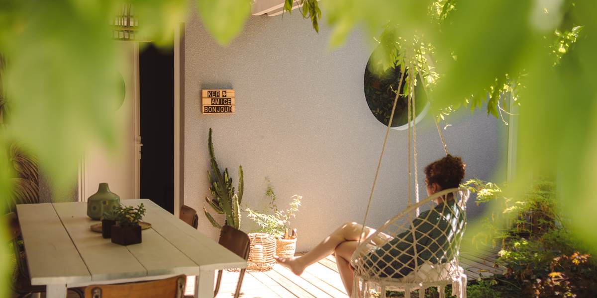 Sous le patio, se laisser bercer par la sérénité du lieu dans un fauteuil suspendu