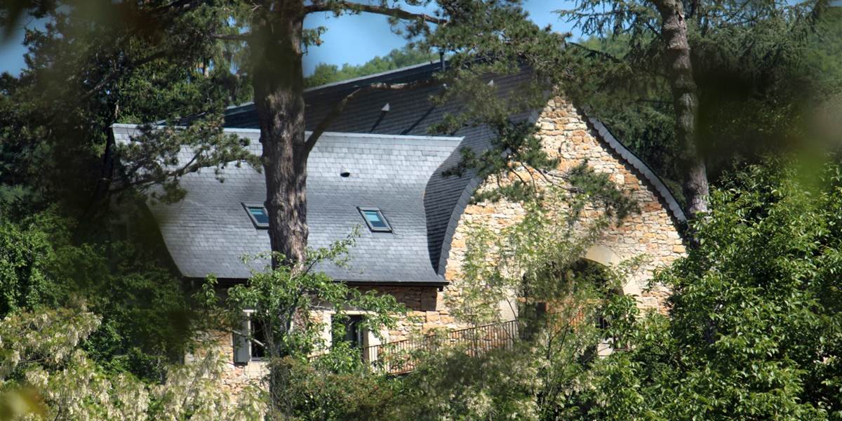 La grange étable vue depuis la vallée révélant la forme atypique de sa toiture à la Philibert Delorme