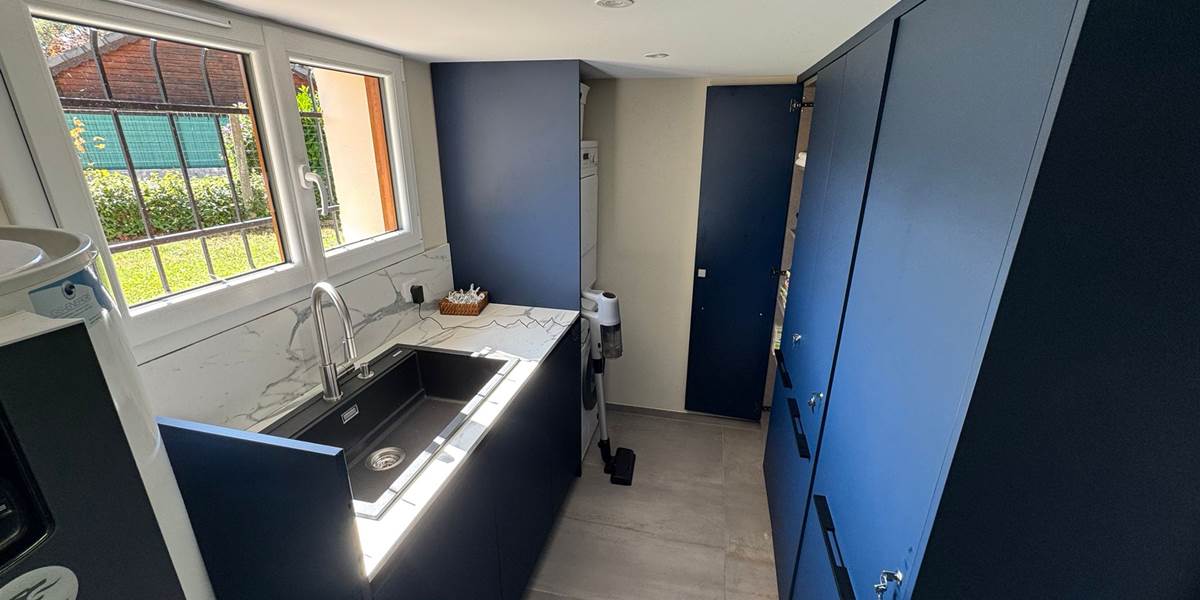 La buanderie au rez-de-chaussée avec lave-linge, sèche-linge et évier