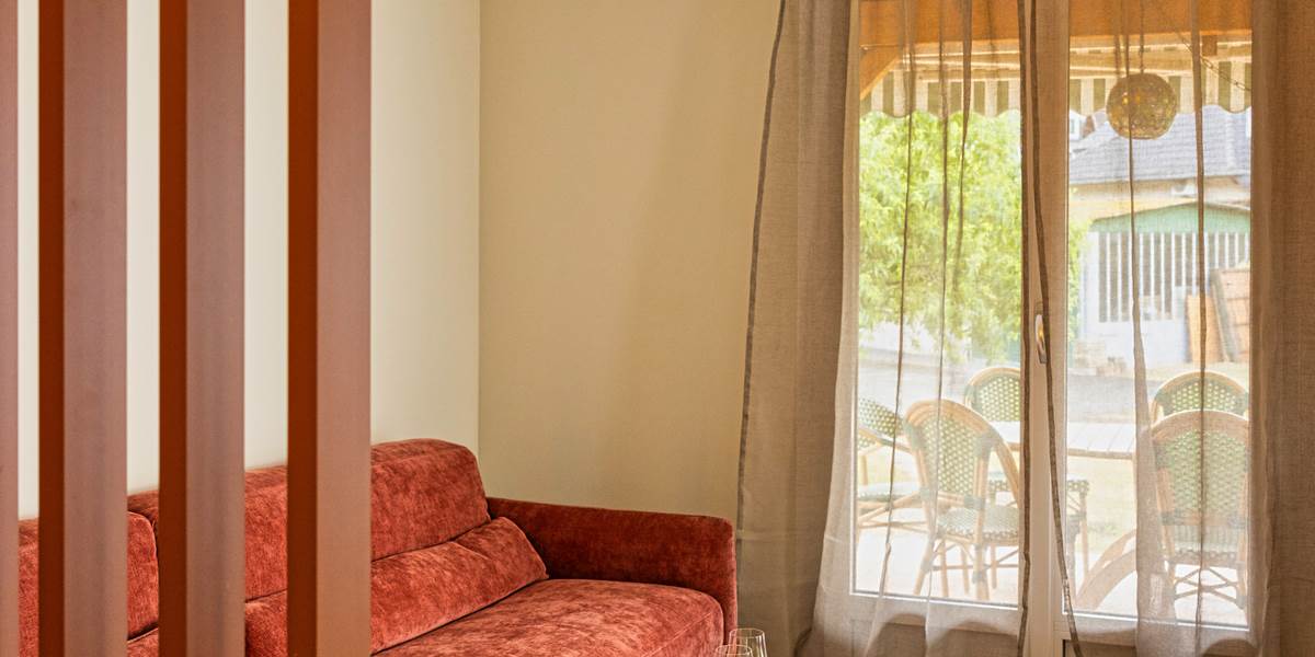 Le salon avec accès à la terrasse couverte et au jardin