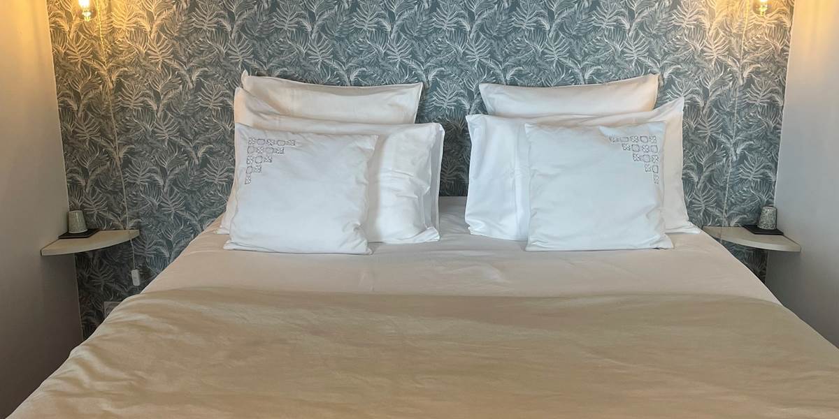 Chambre Tourmaline avec sa literie Queen-size haut de gamme et décoration tropicale