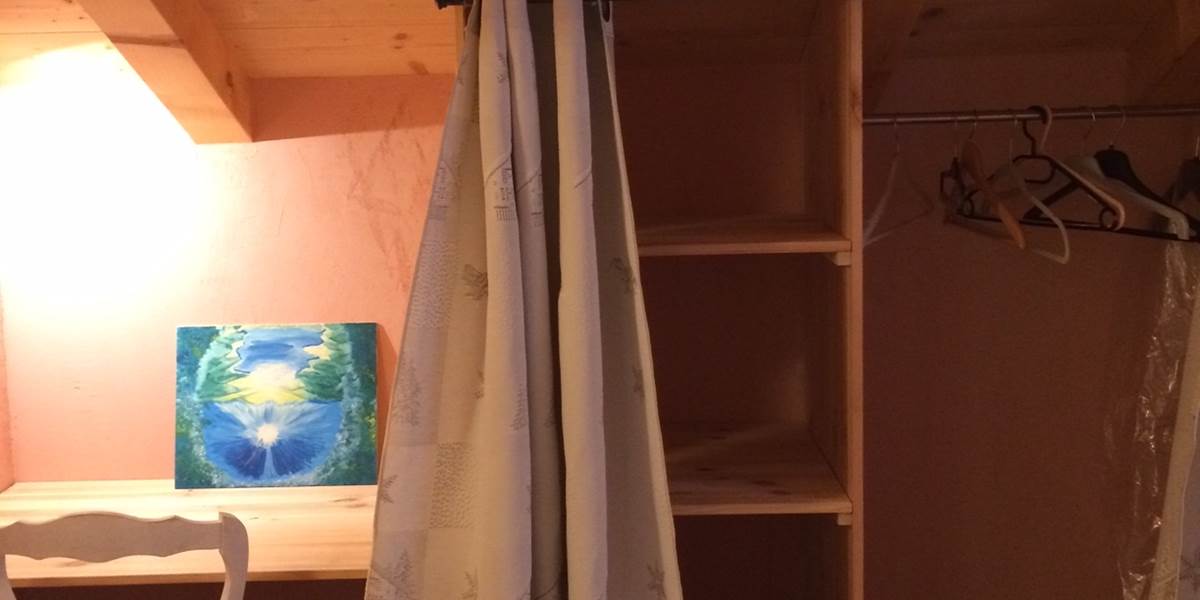 Vue du coin bureau, étagères et penderie de la chambre