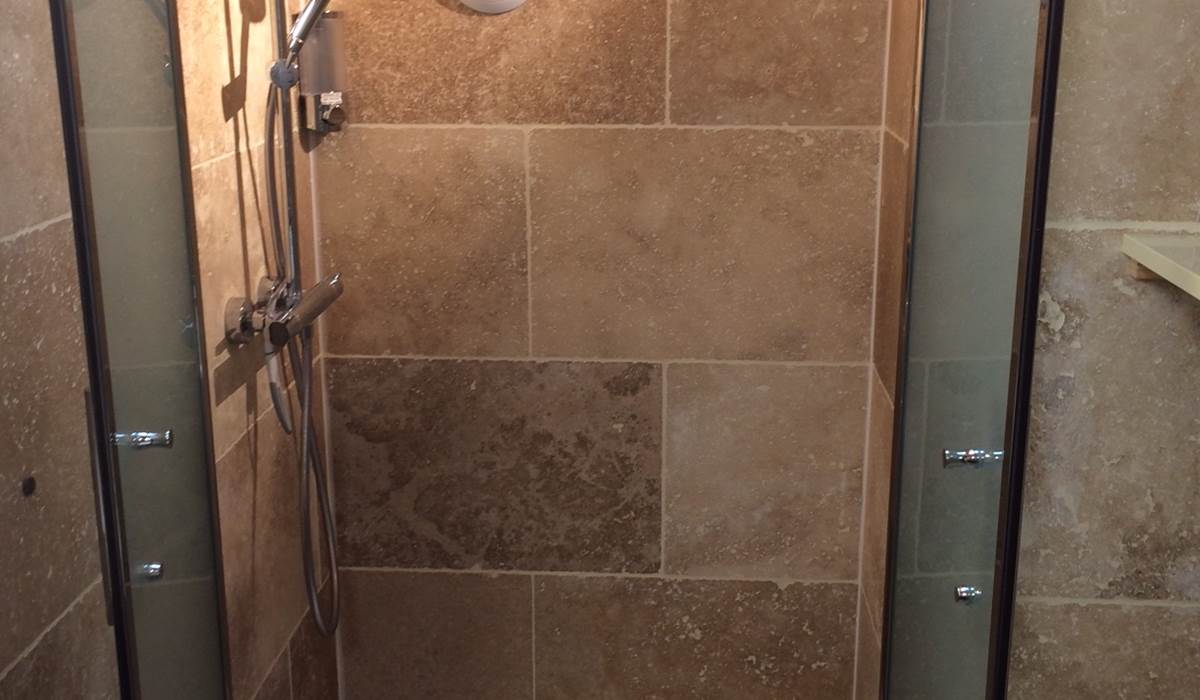 Intérieur de la douche italienne de 100x80 cm avec les porte du pare-douche ouvertes