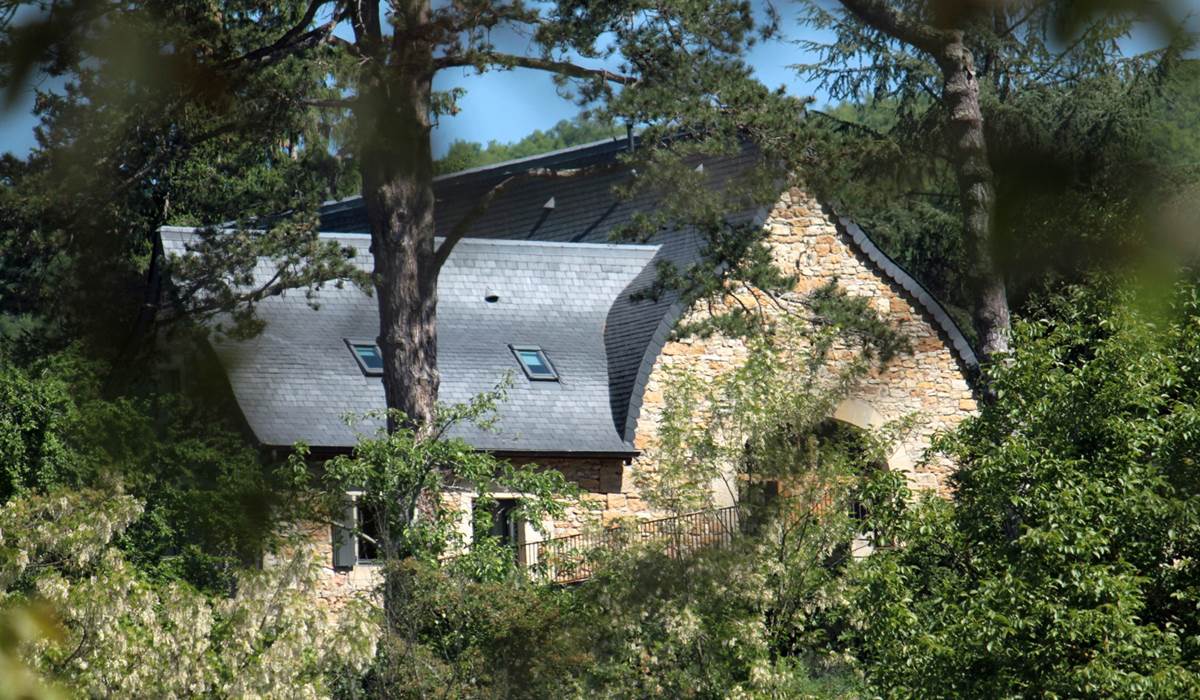 La grange étable vue depuis la vallée révélant la forme atypique de sa toiture à la Philibert Delorme