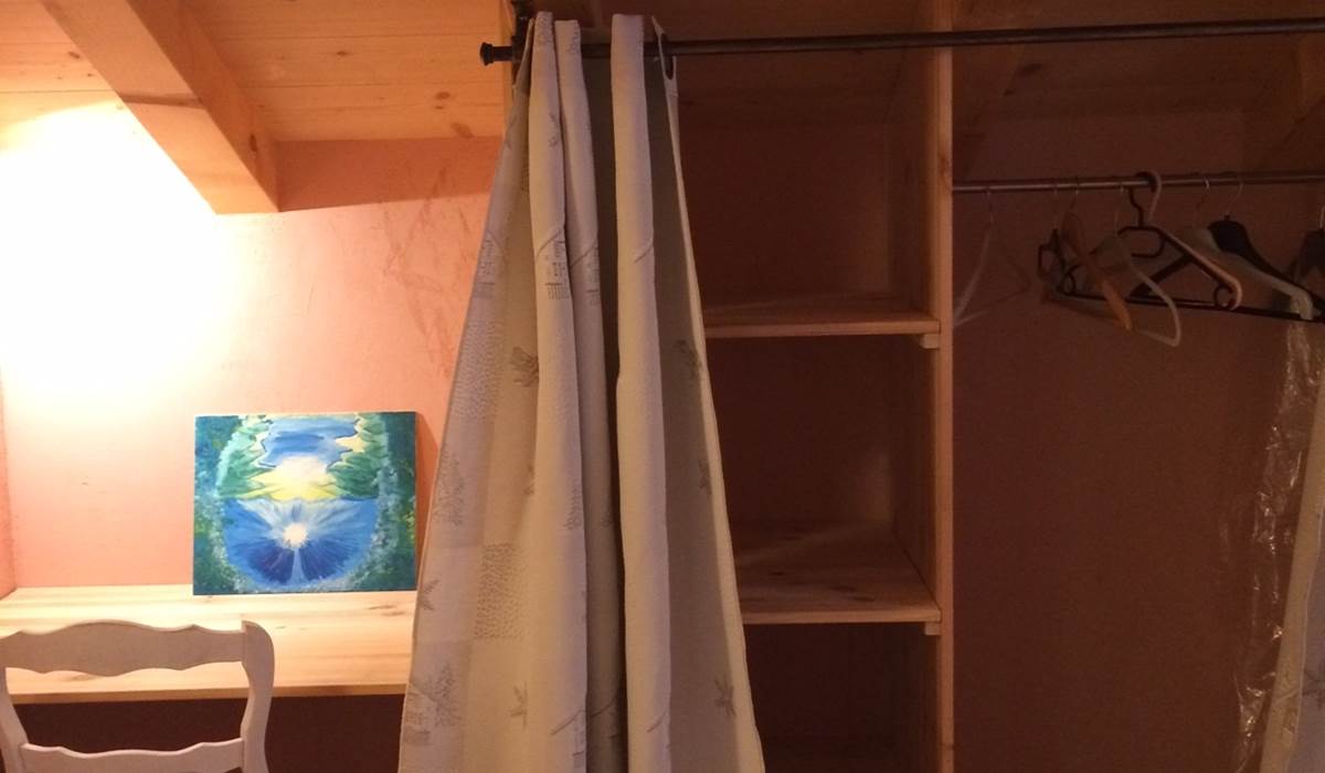 Vue du coin bureau, étagères et penderie de la chambre
