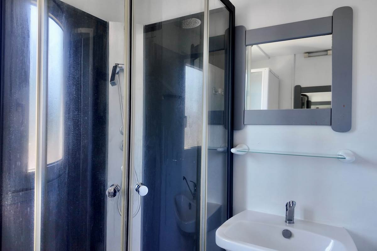 Salle de bain avec tapis de bain et produits de nettoyage