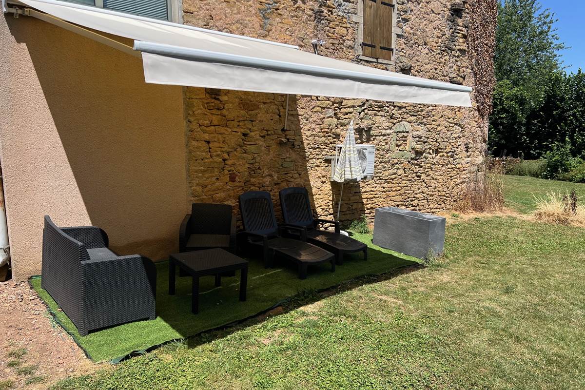 Espace détente et repas dans le jardin sous store banne motorisé