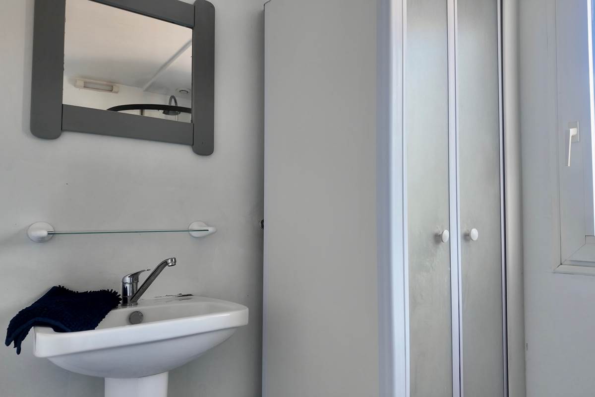 Salle de bain avec tapis de bain et produits de nettoyage