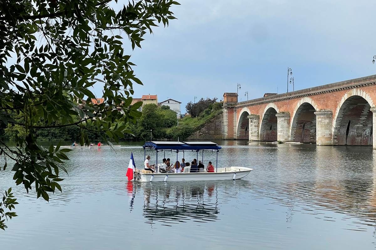 Le bateau 12 passagers Helios Confluences s'apprête à passer sous le Pont Napoléon de Moissac