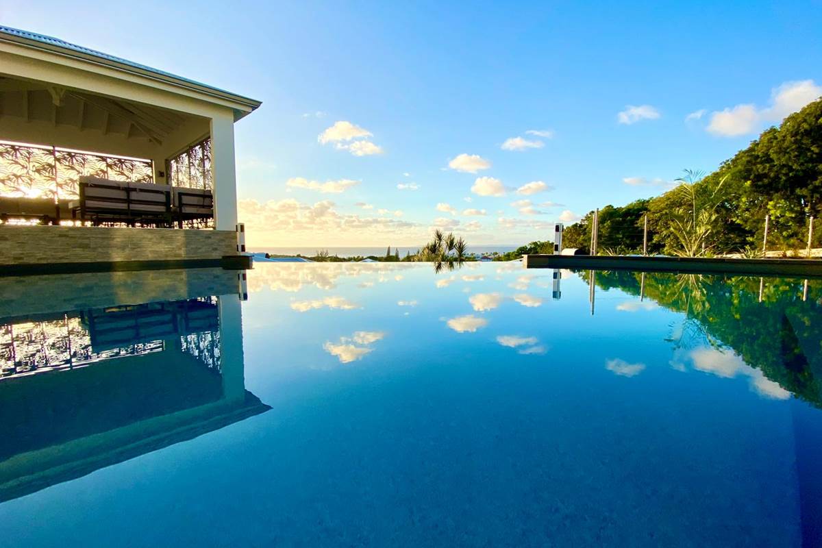 Piscine à débordement vue mer avec coin salon sous le carbet