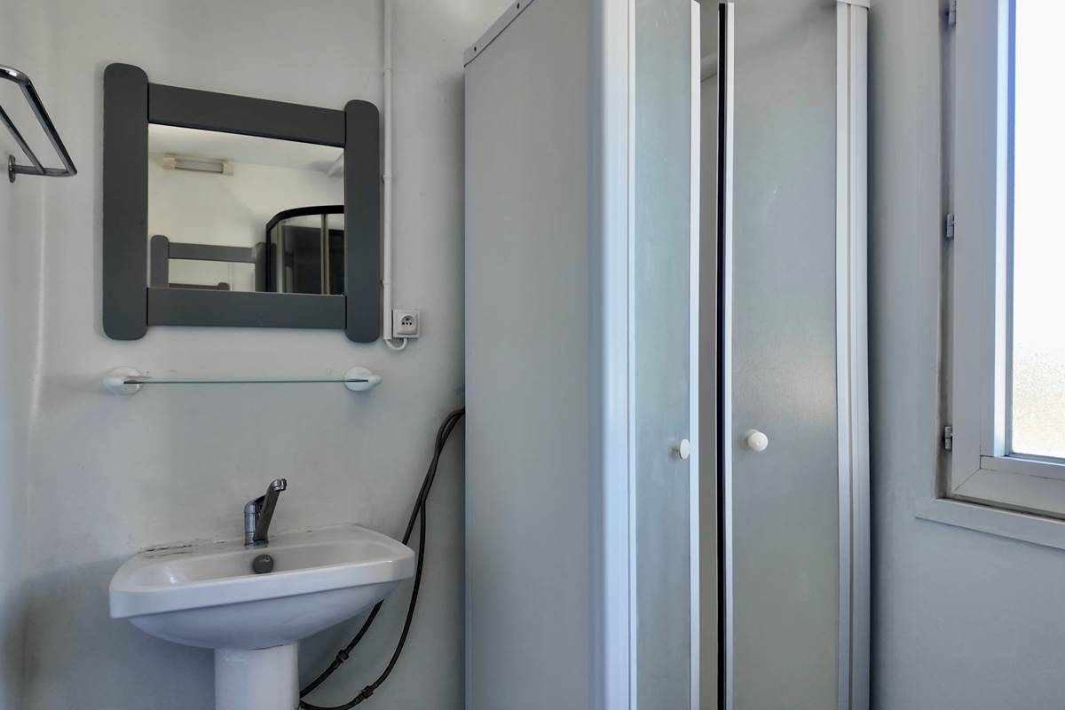 Salle de bain avec tapis de bain et produits de nettoyage
