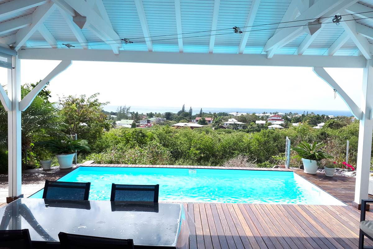 Terrasse couverte ouverte sur la piscine vue mer