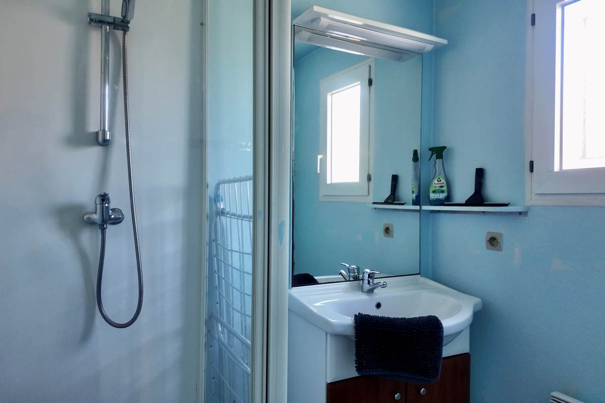 Salle de bain avec tapis de bain et produits de nettoyage