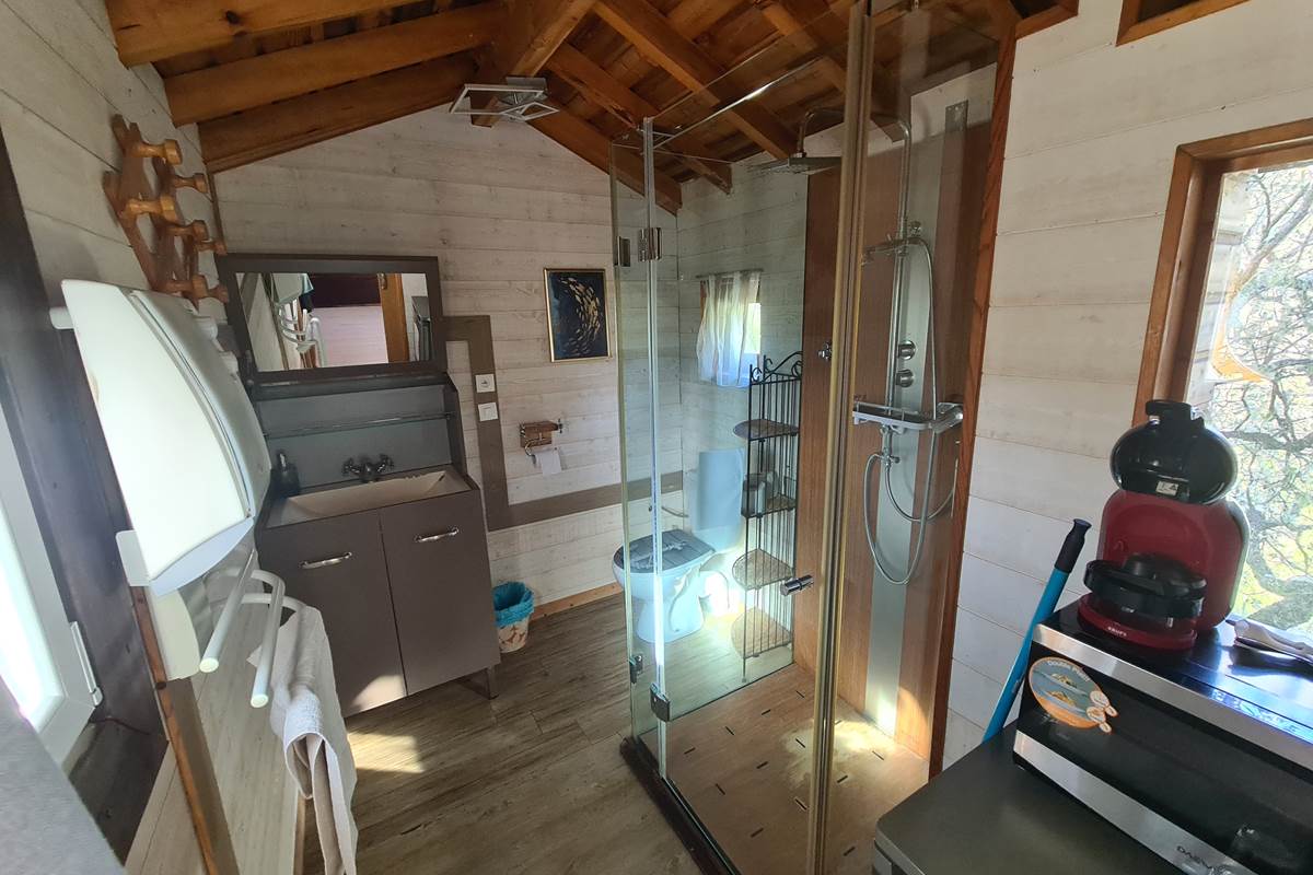 Une jolie salle de bain avec douche, WC, lavabo, et frigo cafetière, bouilloire