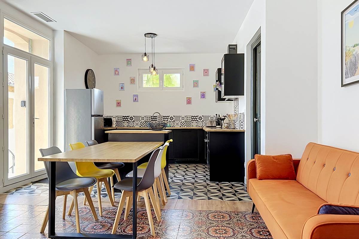 Grande pièce de vie du gîte Le Ramonetage avec salon, salle à manger et cuisine ouverte
