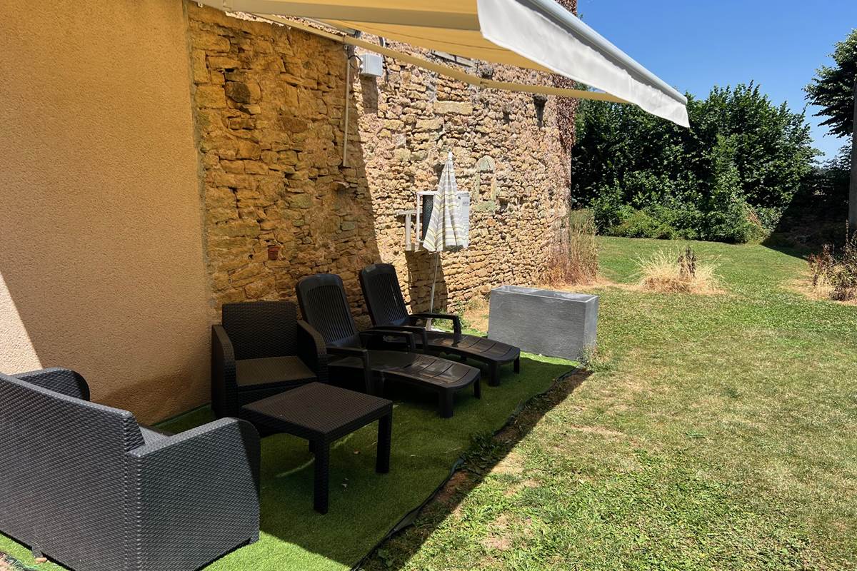 Espace détente et repas dans le jardin sous store banne motorisé