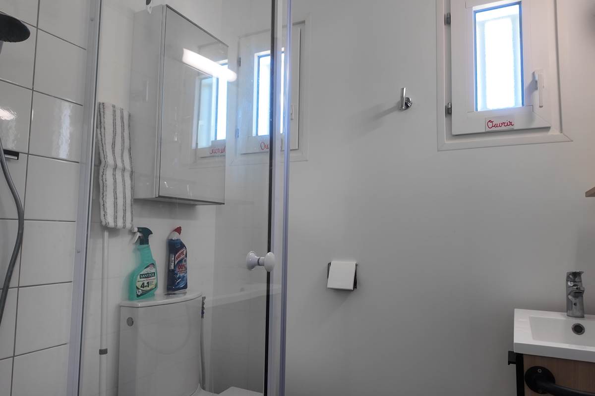 Salle de bain avec tapis de bain et produits de nettoyage