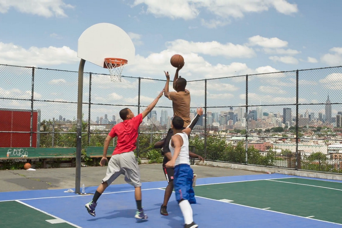 black-and-latinio-teens-play-pickup-basketball-game-at-court-overlooking-manhattan-skyline_vkovlhuw__F0000