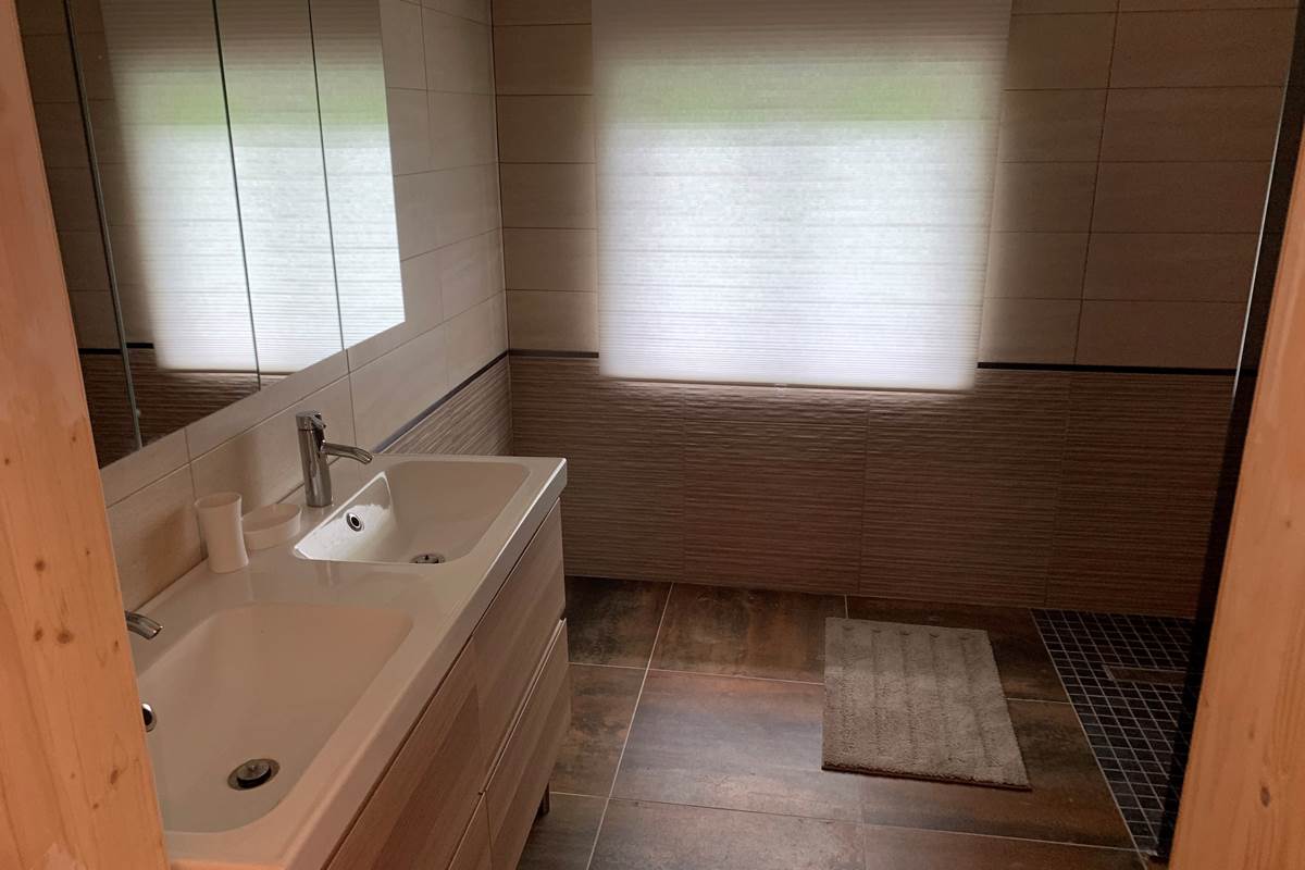 Salle de bain privative attenante à la chambre orange avec douche à l'italienne, pratique et confortable pour les séjours en groupe dans notre gîte rural du Pas-de-Calais.