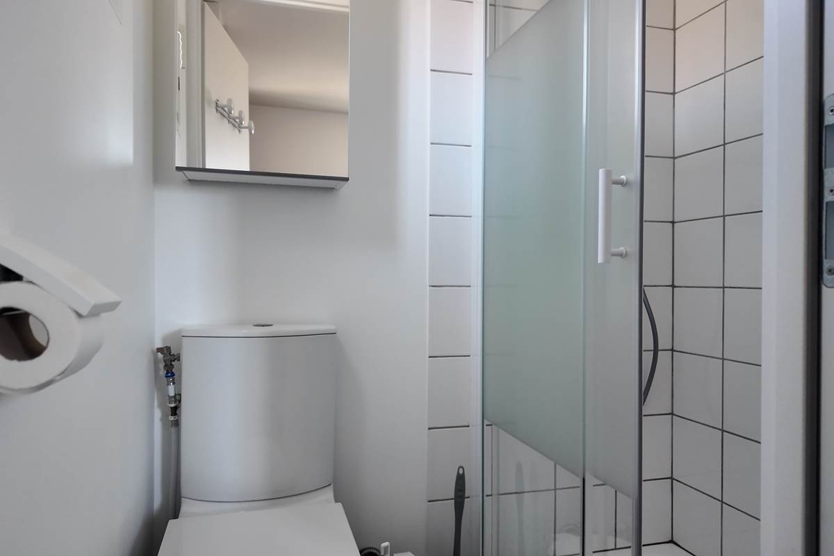 Salle de bain avec tapis de bain et produits de nettoyage