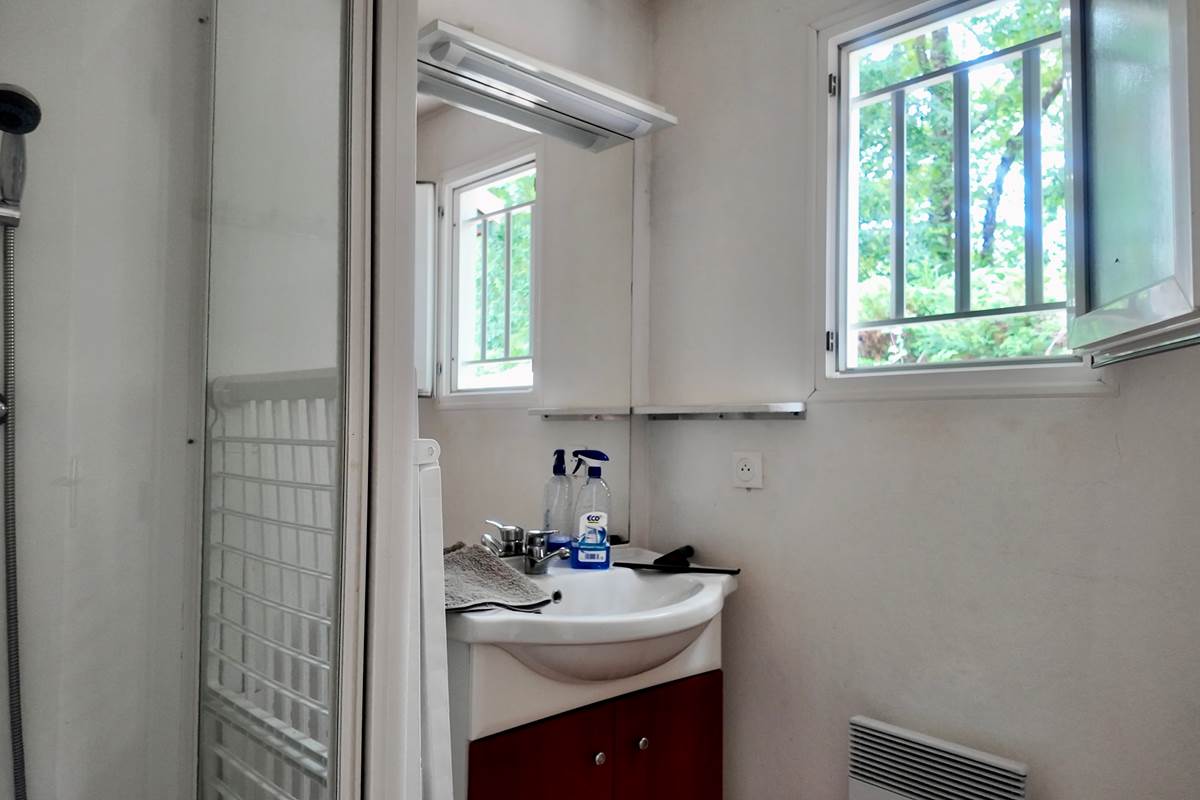 Salle de bain avec tapis de bain et produits de nettoyage