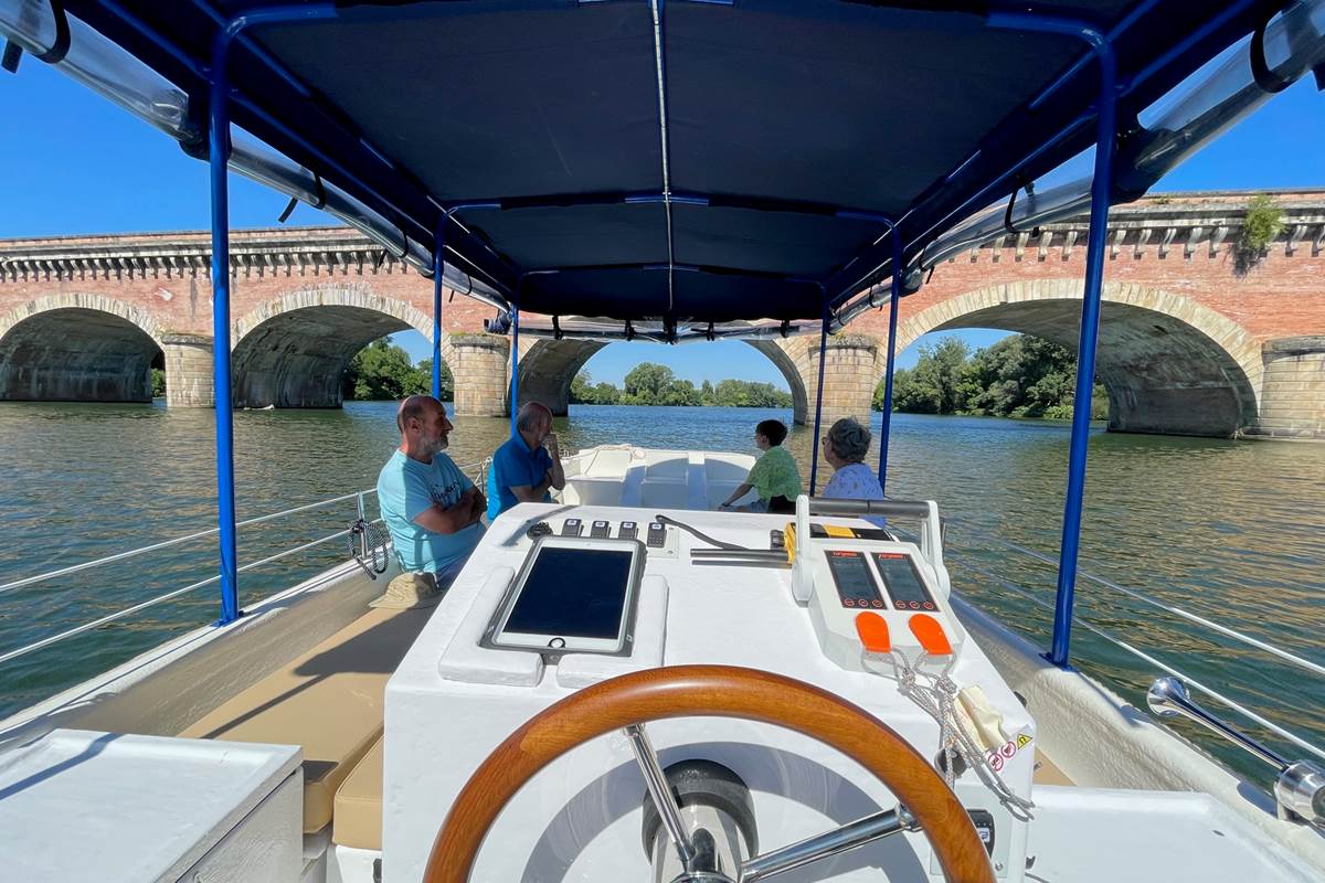 Le bateau à passagers Helios Confluences s'apprête à passer sous le Pont Napoléon de Moissac