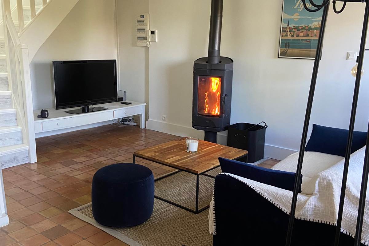 Le salon avec TV et poêle à bois