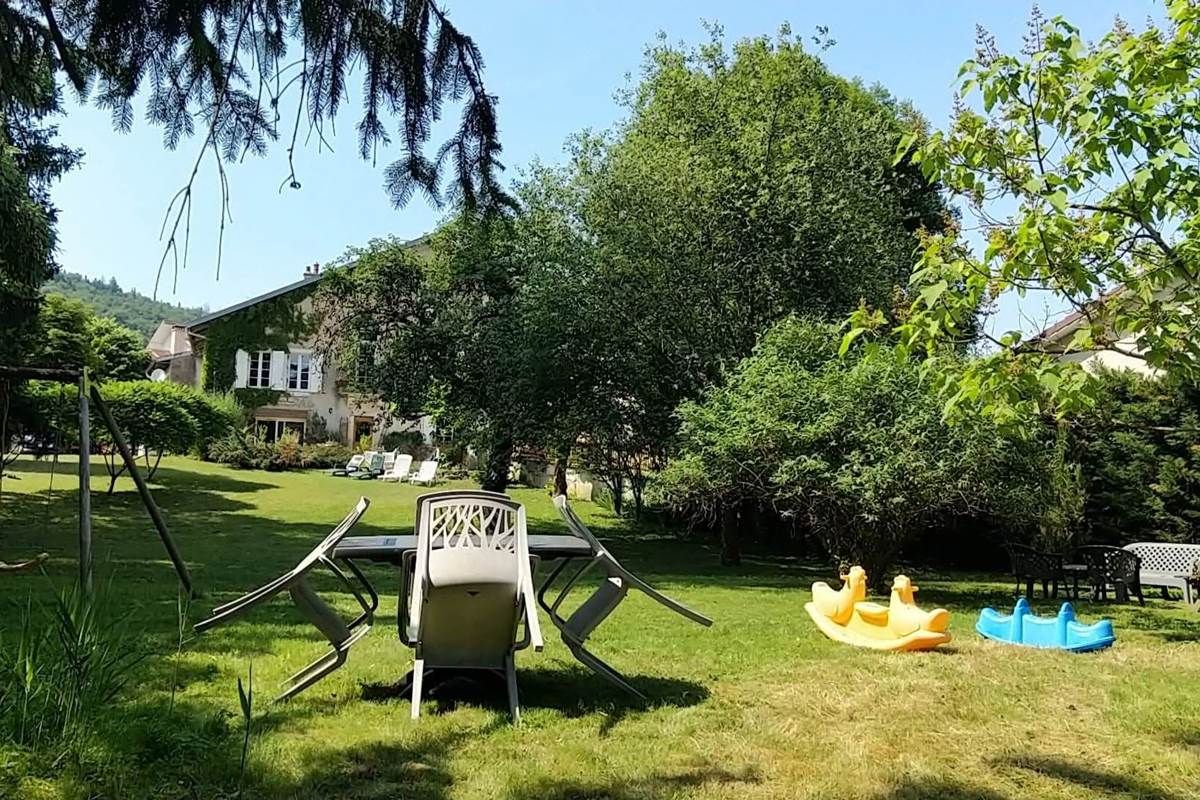 Façade principale avec lierre et parking gratuit à Oyonnax- Bellignat. Vue du bas du parc