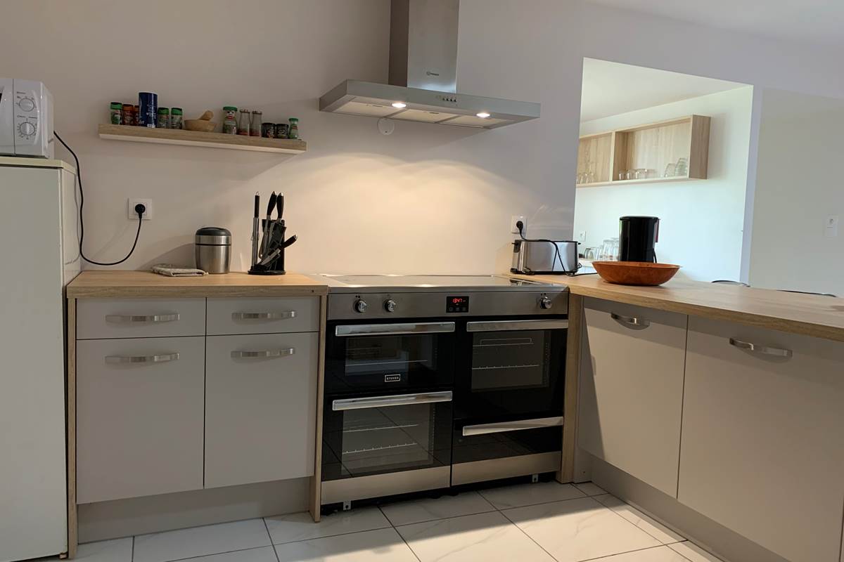 La cuisine piano / micro onde / frigo / table de travail / rangements