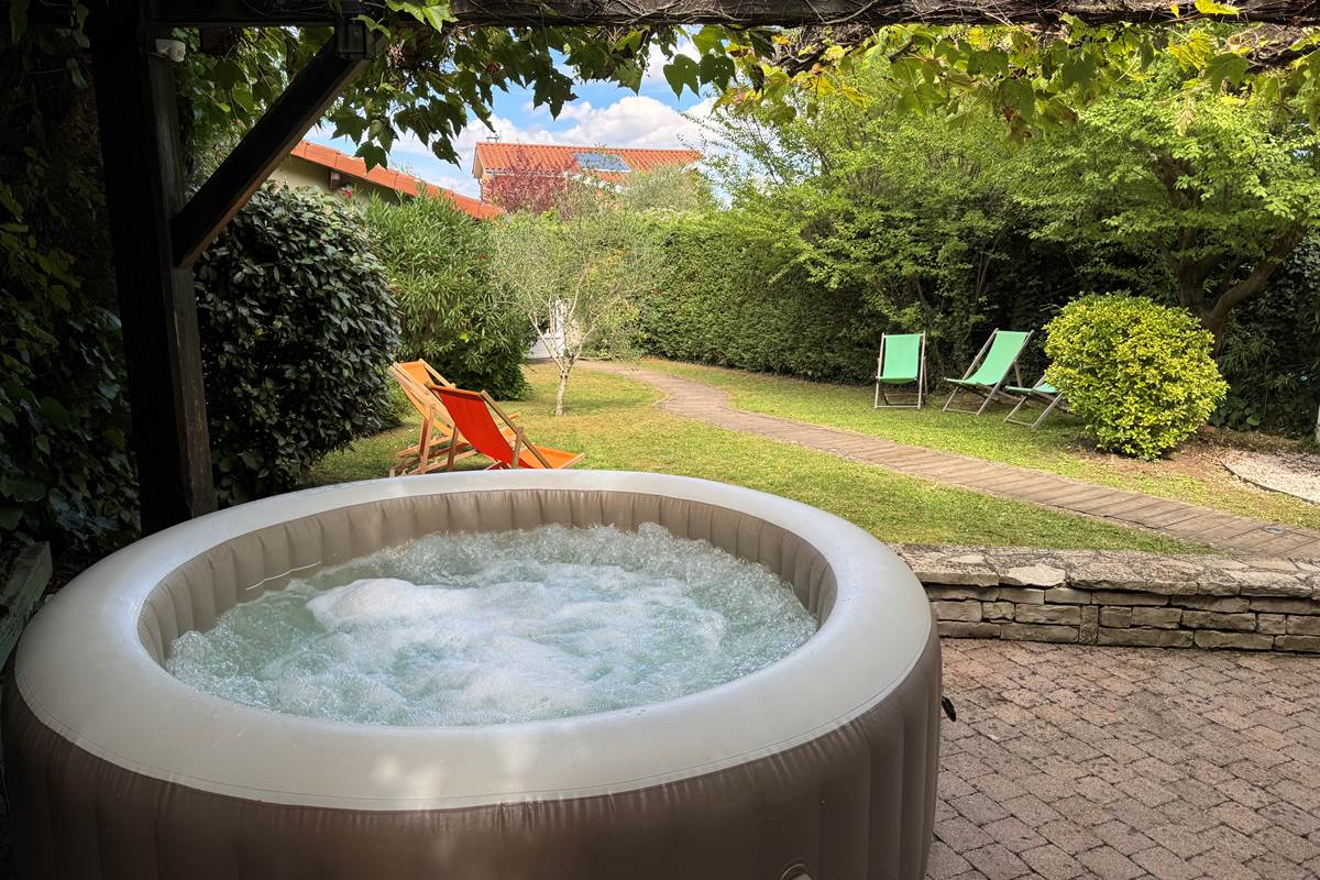 Le jacuzzi 4 personnes et le jardin clos et arboré