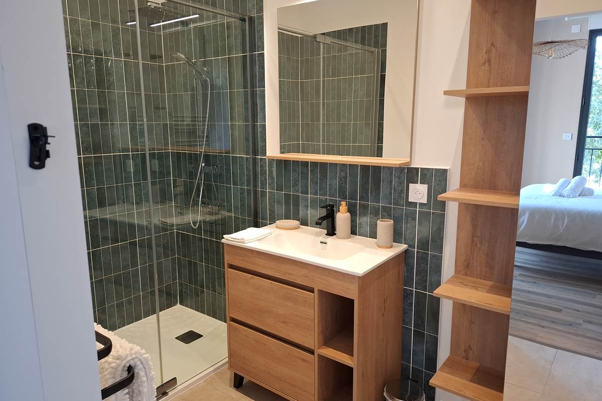 Salle de bain privative de la suite parentale du gîte Le Pressoir à Montblanc, douche et rangements.
