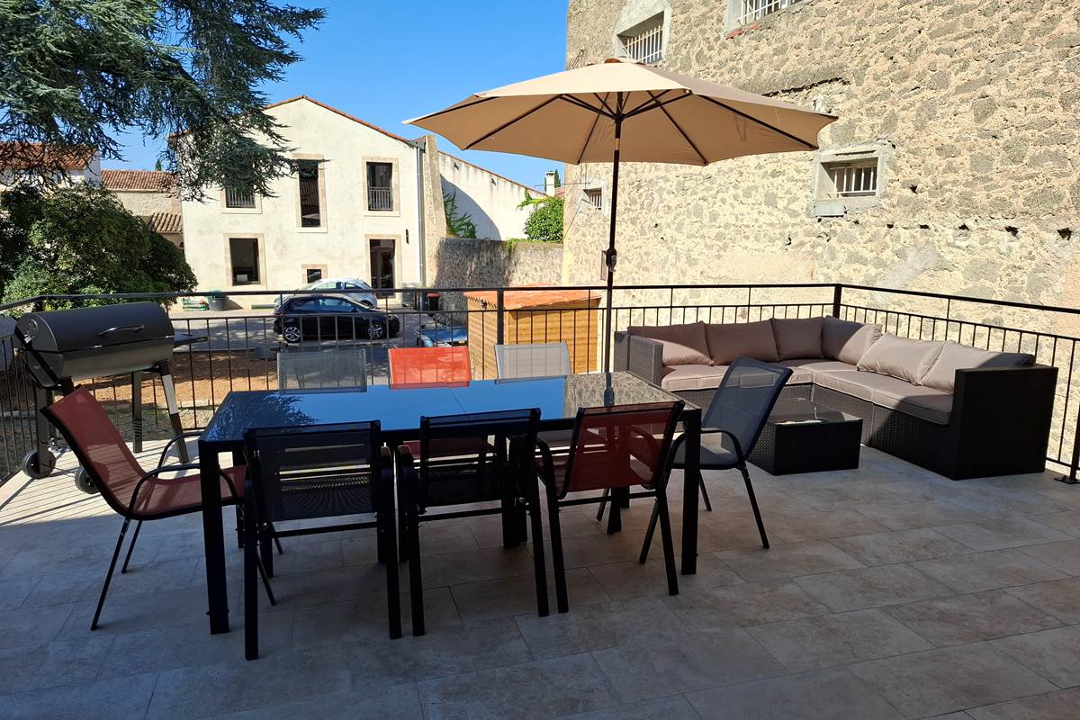 Terrasse avec table et barbecue du gîte Le Pressoir, 2 chambres.