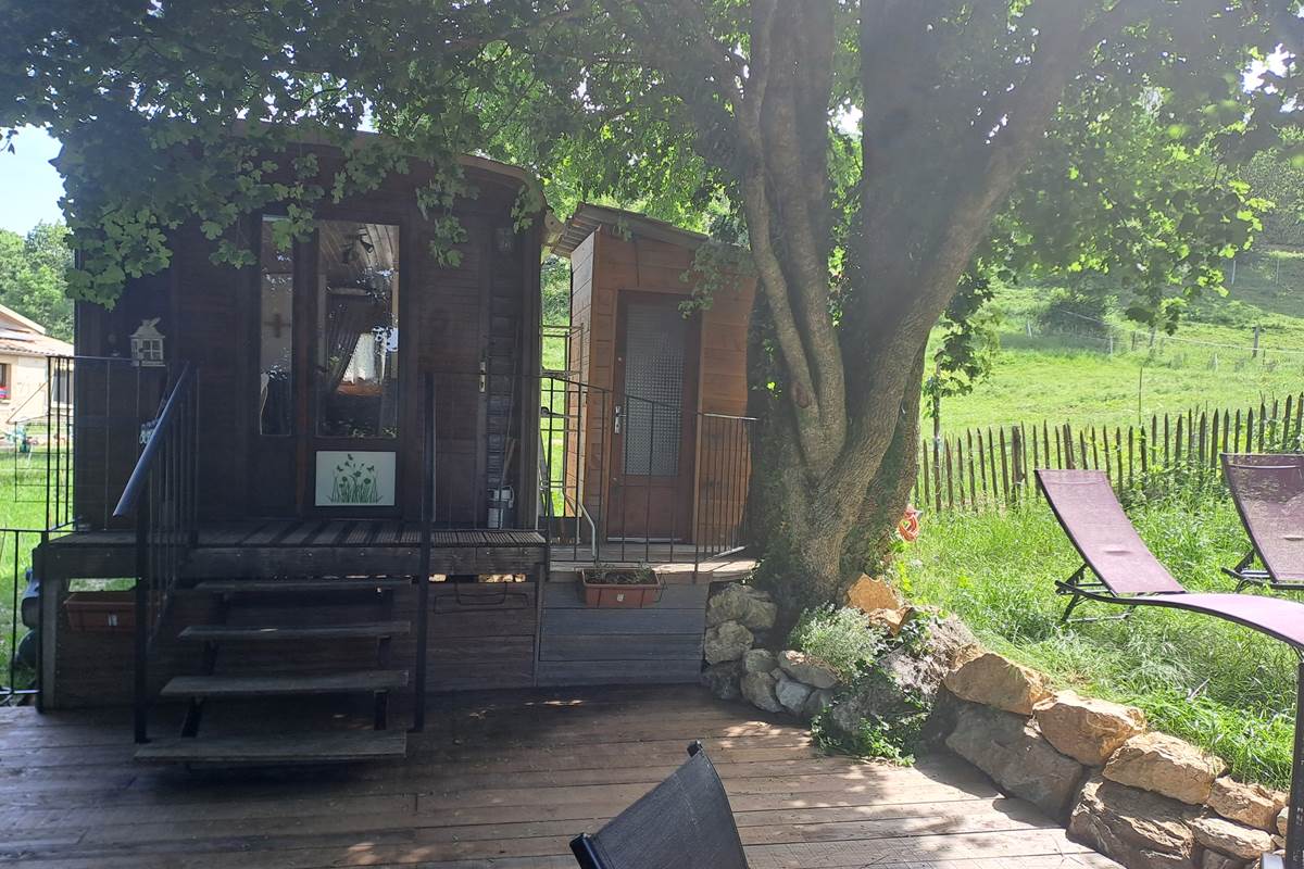 WC privée contre la roulotte et zone de détente avec 2 transats