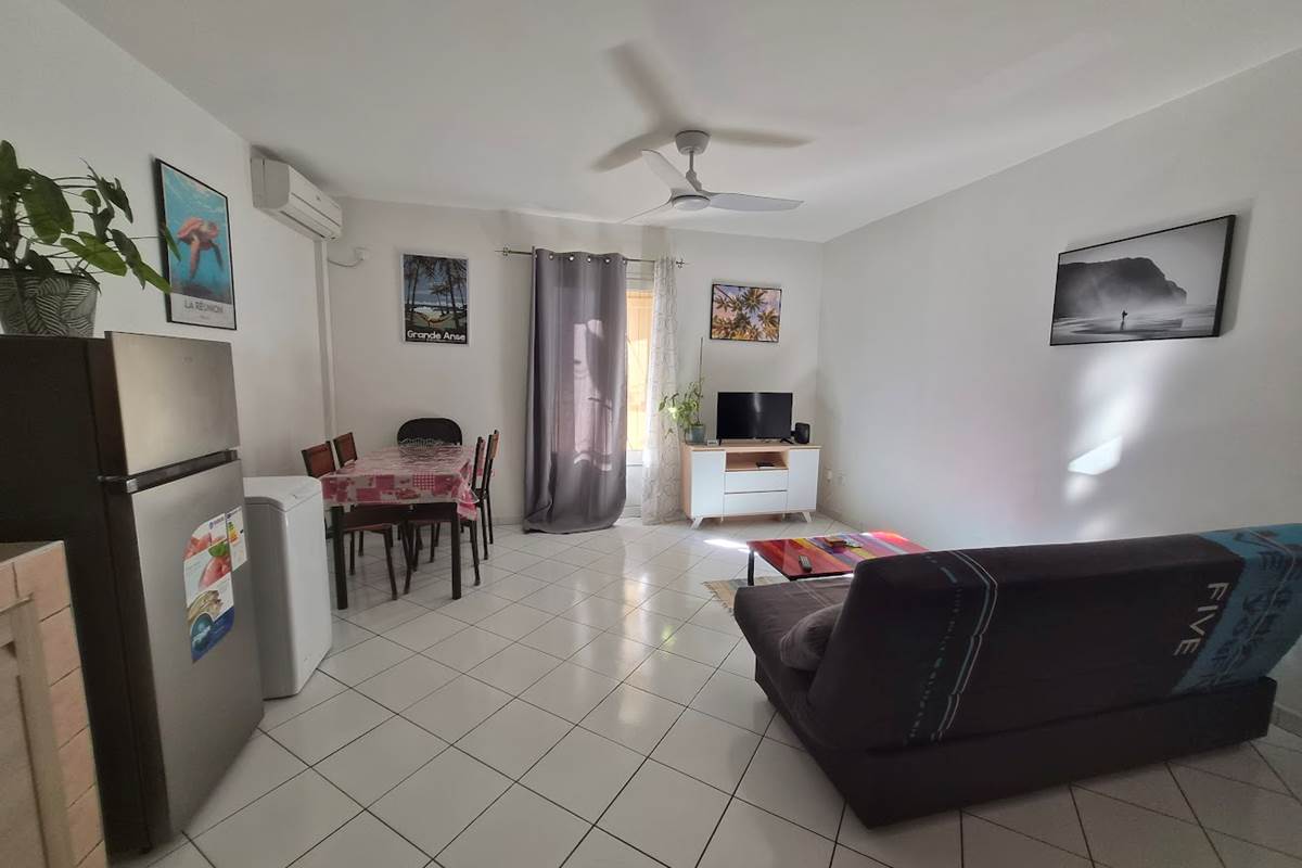 T2 Frangipanier climatiseur, séjour, vue d'ensemble, plaque de cuisson, table à manger