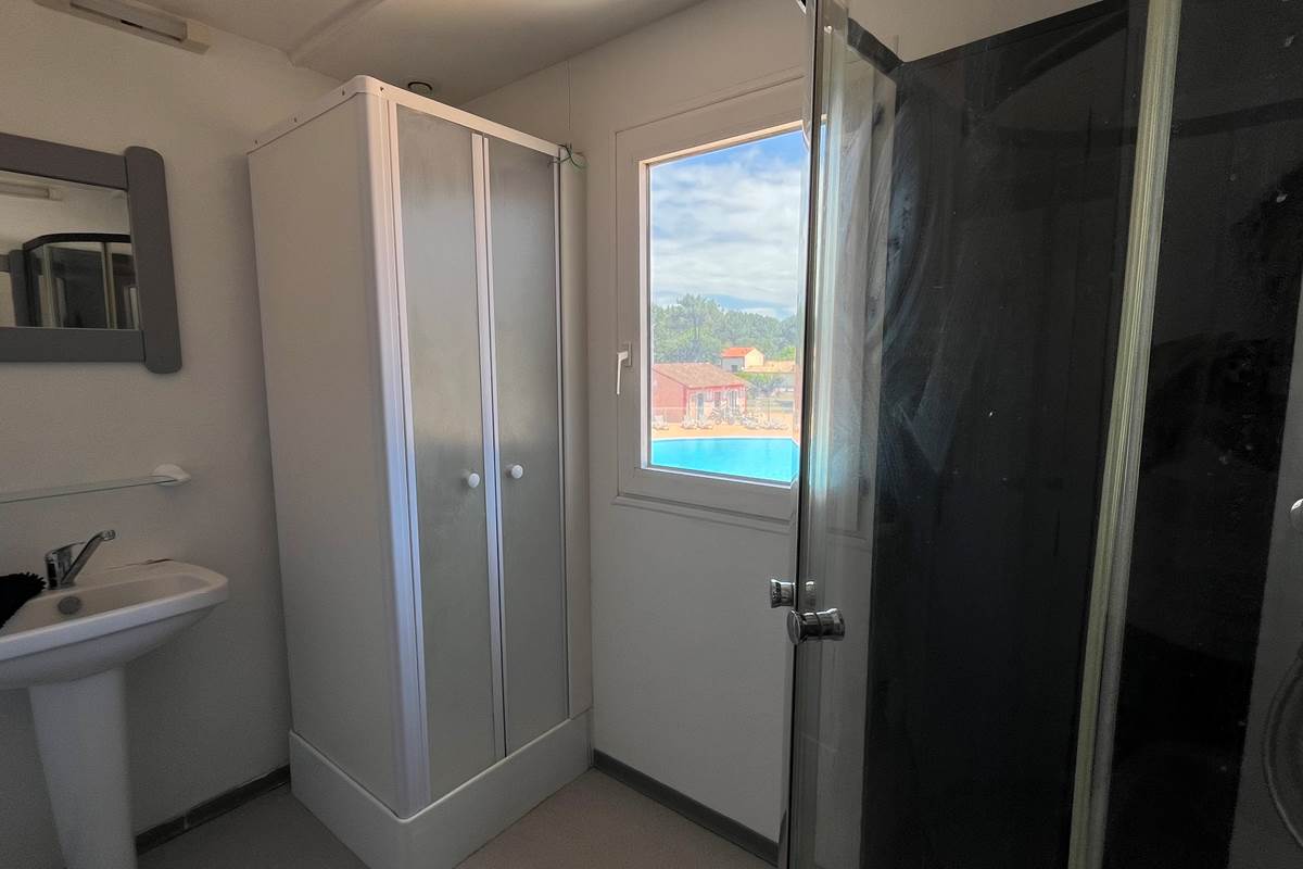 Salle de bain avec tapis de bain et produits de nettoyage*
