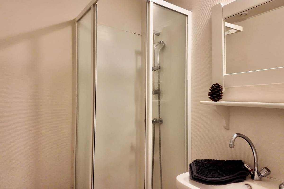 Salle de bain avec tapis de bain et produits de nettoyage