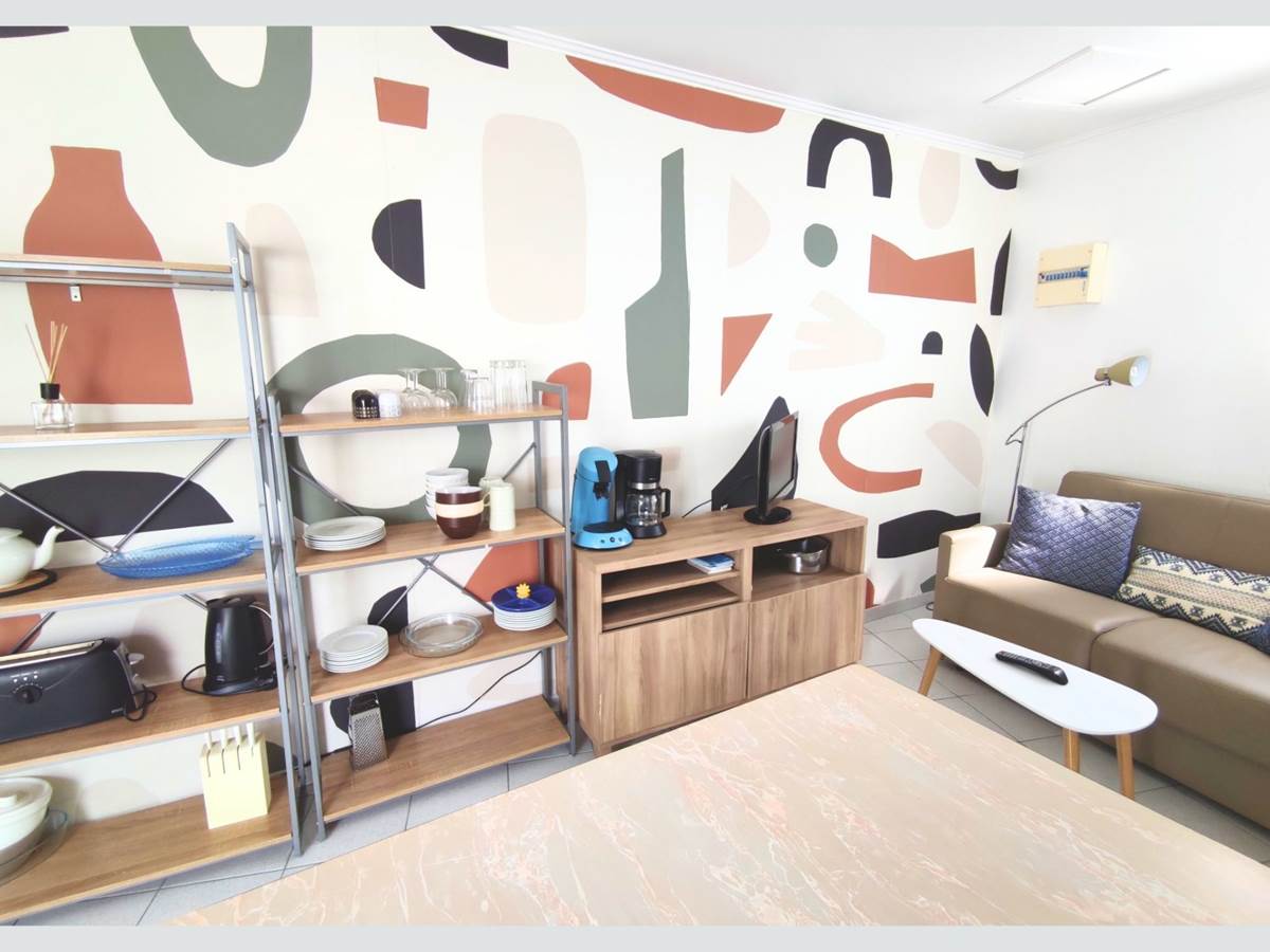 Maison Réthaise 2 – Séjour cosy et graphique Ambiance contemporaine dans un espace bien agencé, parfait pour savourer des moments de détente en centre-ville.