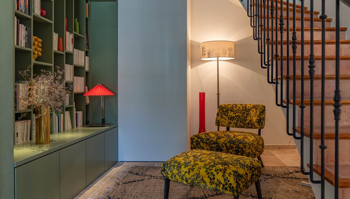 A l'accueil du logis, un salon avec un fauteuil iconique Caravane vous permet une pause lecture au plus près de la bibliothèque