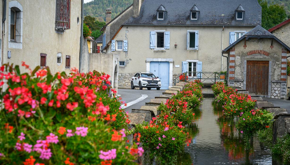 Gîte du Moulin : Le canal fleuri et la façade du moulin.