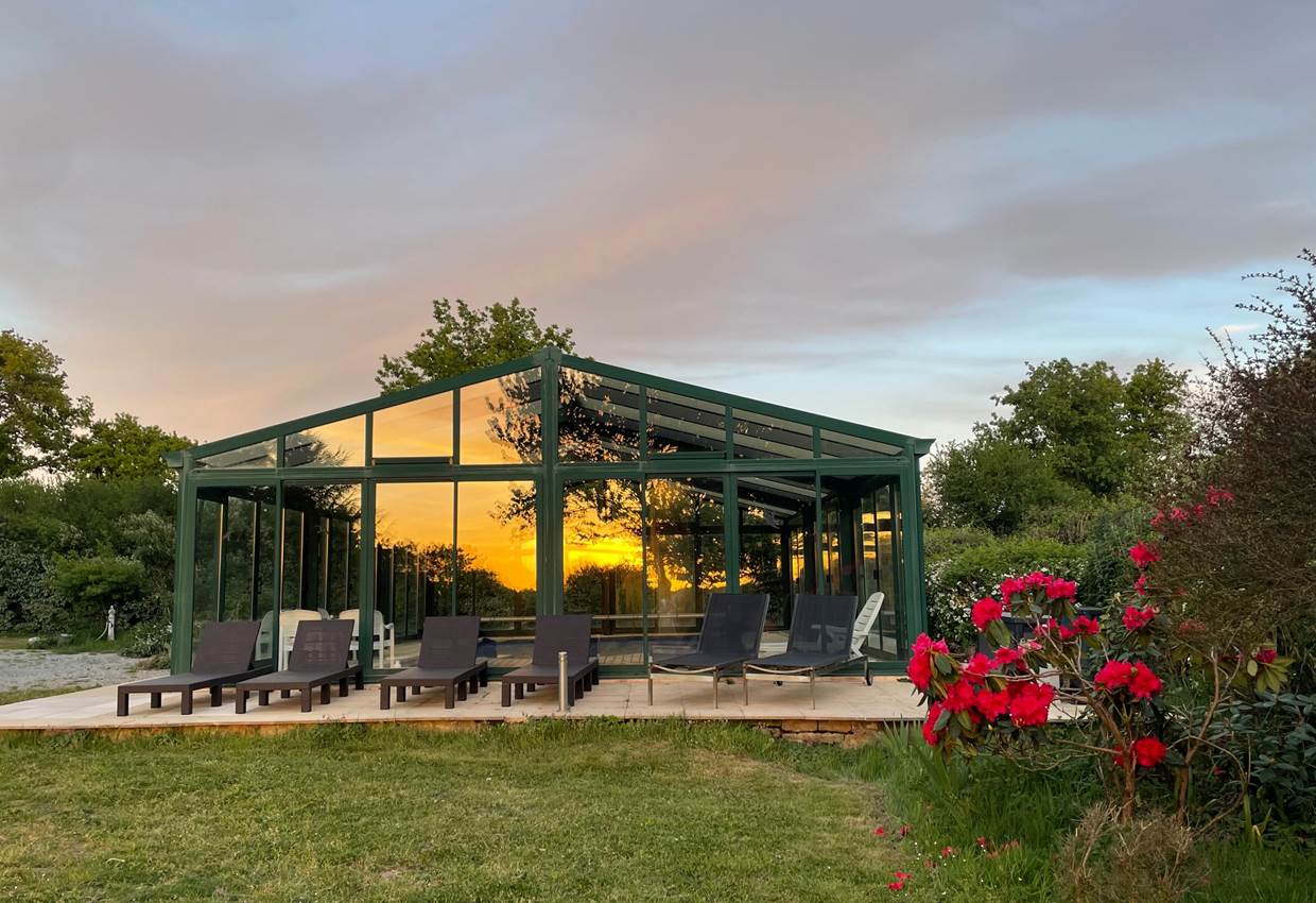 Piscine couverte vue sur le parc fleuri