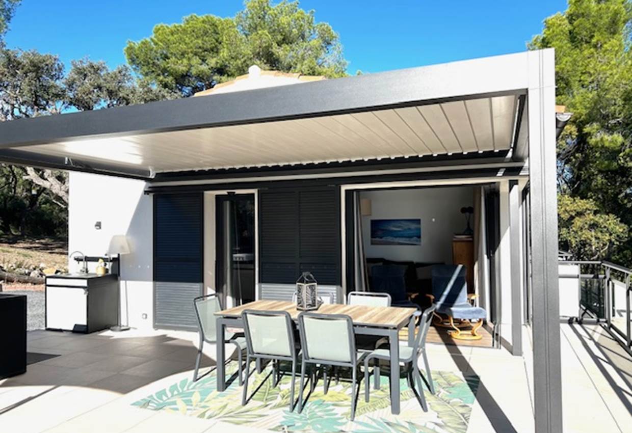 Espace repas extérieur protégé par une pergola bio-climatique