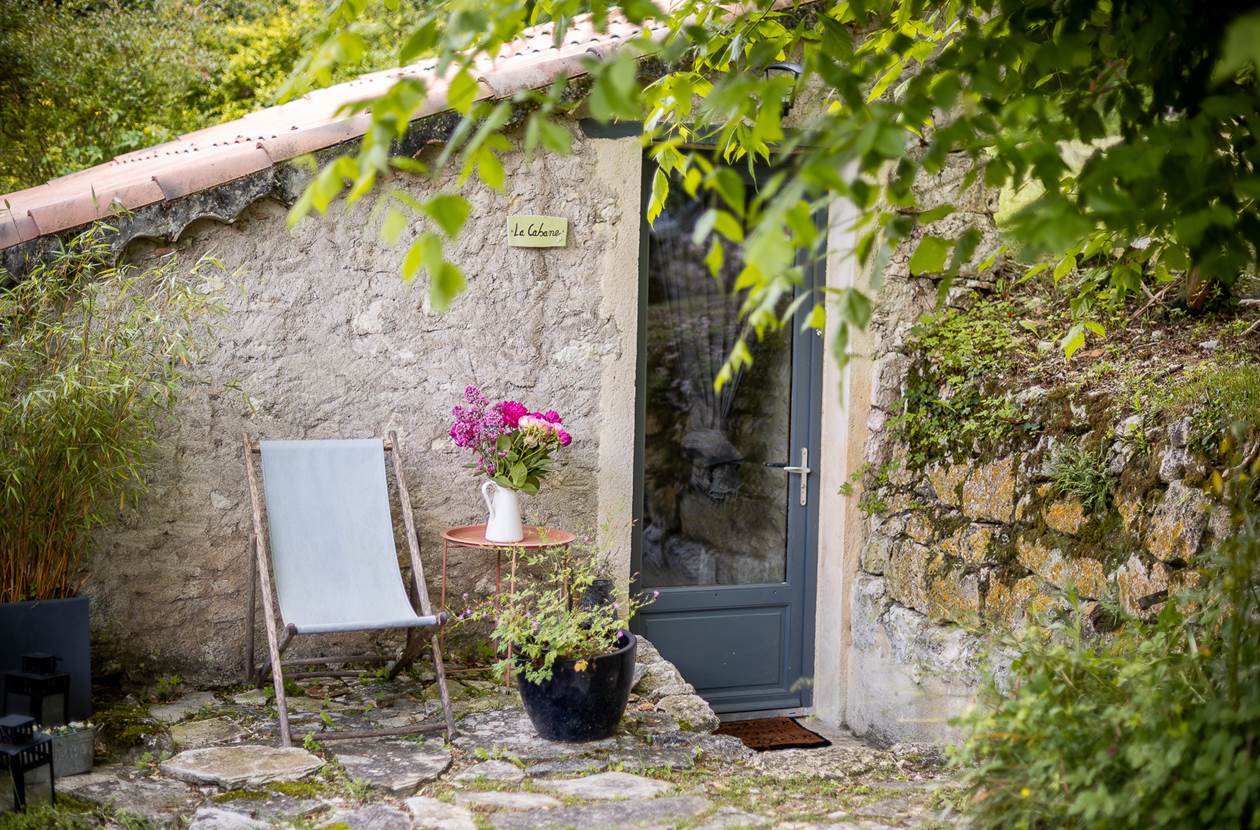 Façade en pierre de la Cabane avec coin détente extérieur