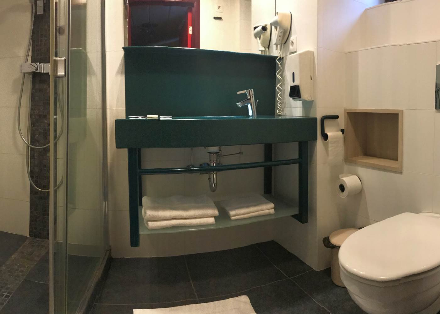 Salle de Bain privative comprenant une douche italienne, un lavabo, un sèche cheveux et toilettes. Savon, shampoing / douche, papier wc, serviettes de main et serviettes de bain.